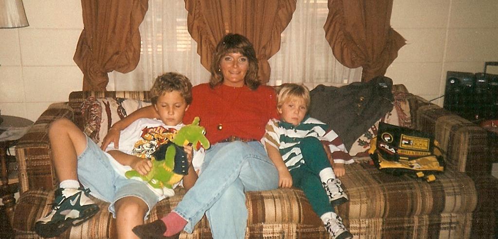 Marsha Colbey sits between her two sons on the couch in her home in 1997